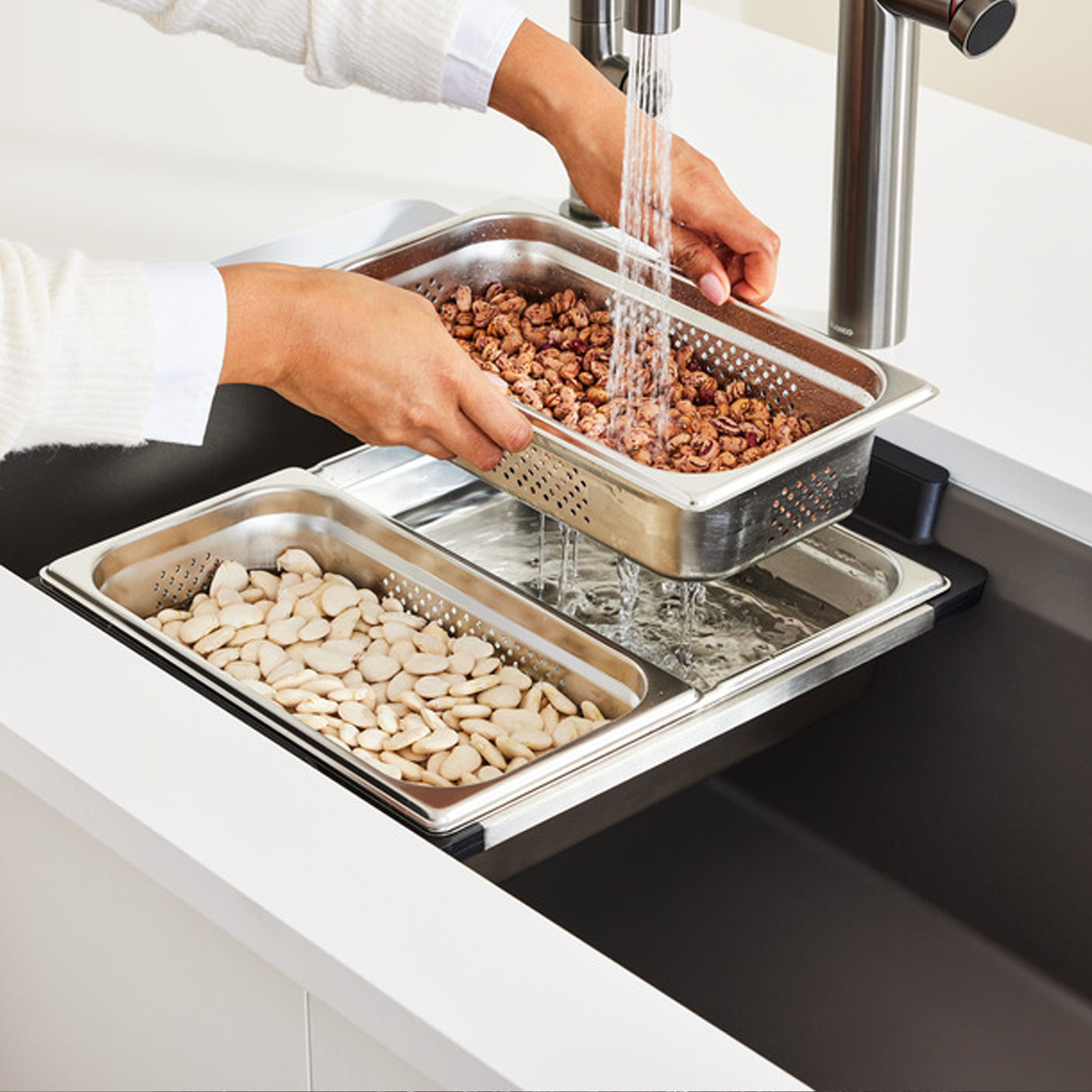 Blanco Inteos kitchen workstation sink with stainless steel colanders being used to rinse beans