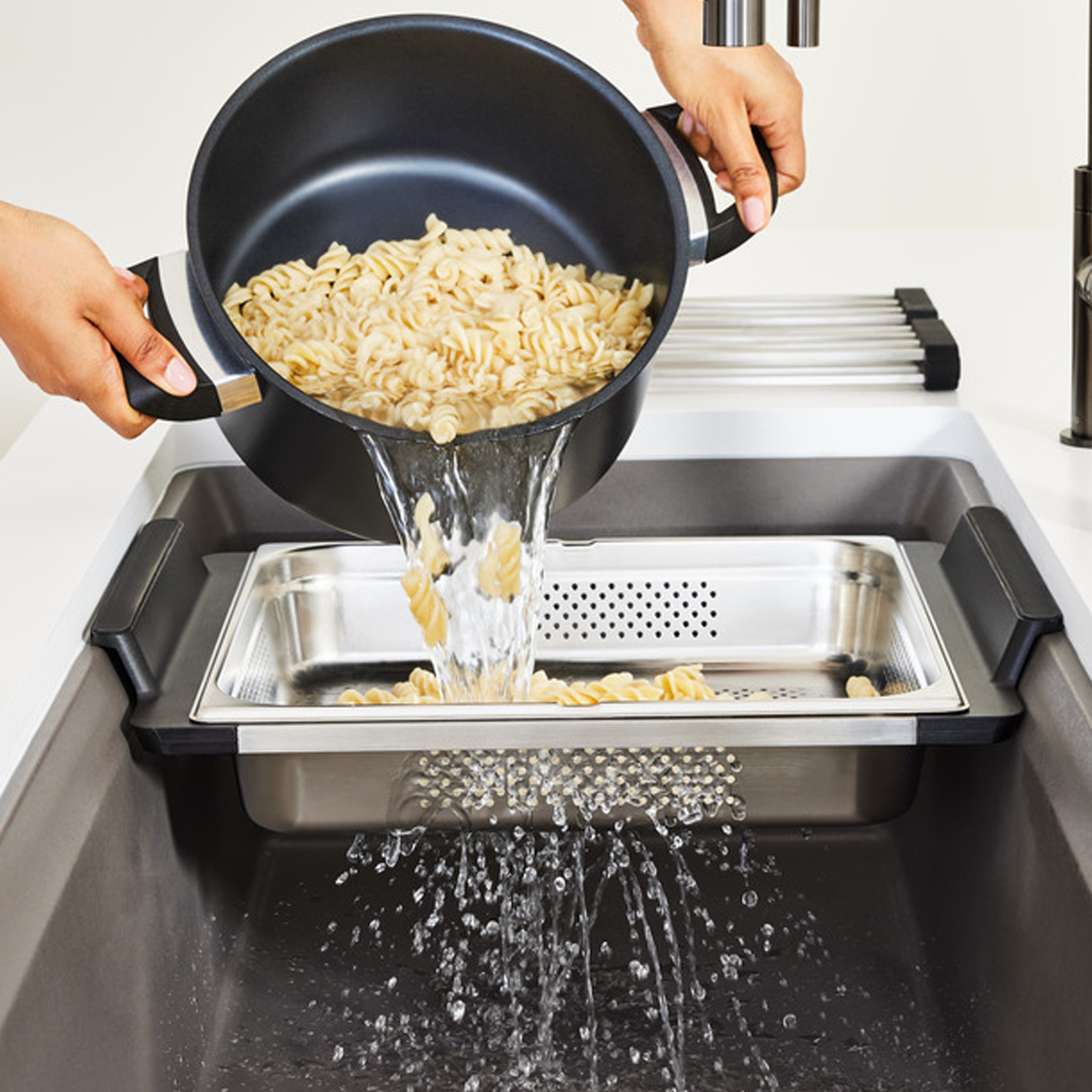 Blanco Inteos kitchen workstation sink with integrated strainer shown straining pasta