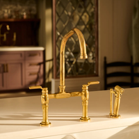 Close-up view of Brizo Faircroft™ deck-mount riser faucet in luxe gold finish shown installed in kitchen.