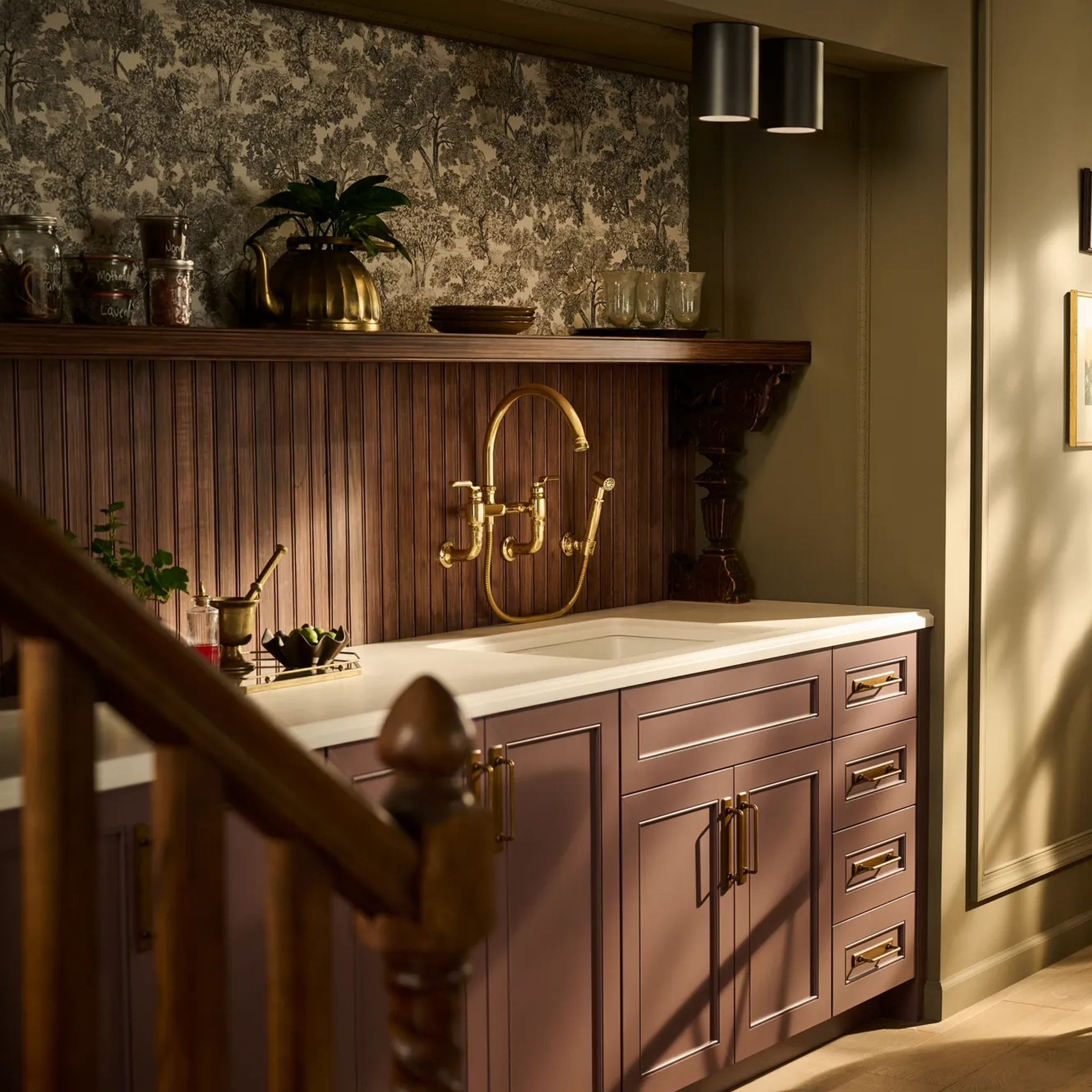 Brizo Faircroft wall-mount bridge faucet and side spray in in a traditional kitchen with wood paneling and custom cabinetry