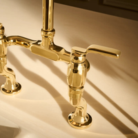 Close up view of Brizo Faircroft bridge faucet industrial lever handle kit in luxe gold