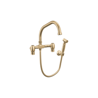 Brizo Faircroft wall-mount bridge faucet with angled spout and side spray in luxe gold finish