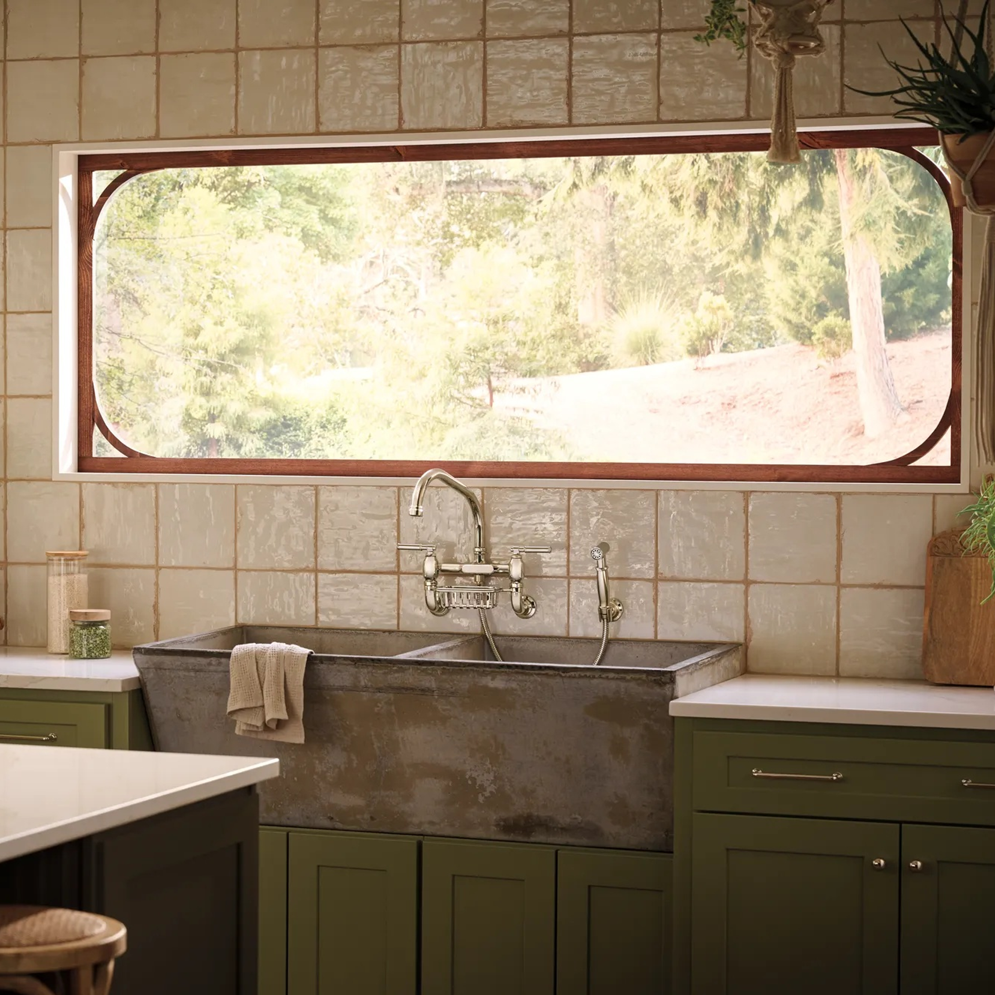 Brizo Faircroft wall-mount bridge faucet and side spray installed above a dark farmhouse sink.