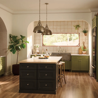 Brizo Faircroft wall-mount bridge faucet and side spray in contemporary kitchen with olive-green cabinets and central island