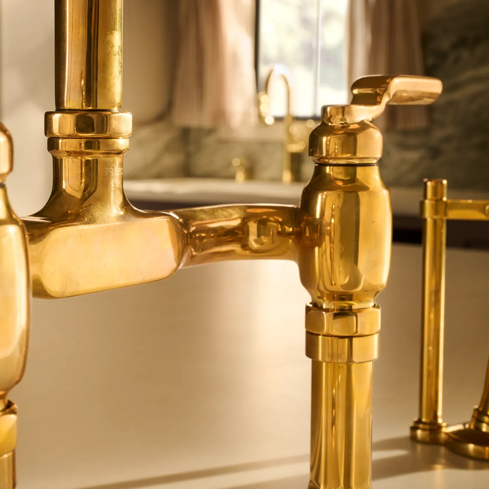 Close-up shot of Brizo Faircroft deck-mount bridge faucet and side spray in unlacquered bass