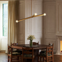 Kuzco Calla Chandelier in brushed gold above dining table