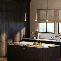 Three Kuzco Calla Pendant Lights in brushed gold finish over kitchen island
