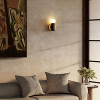 8-inch Kuzco Calla wall sconce in brushed gold and black vegan leather in living room