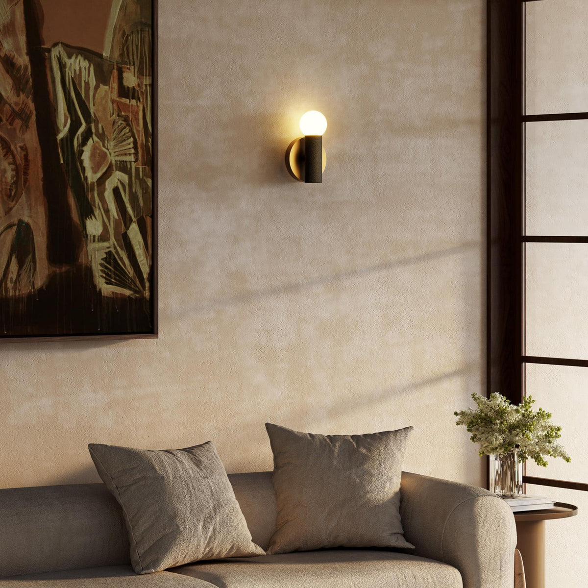 8-inch Kuzco Calla wall sconce in brushed gold and black vegan leather in living room