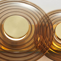 Close-up view of Hudson Valley Griston wall sconce with amber glass discs and brass center