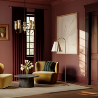 A luxury living room interior featuring an Eula floor lamp by Hudson Valley, mustard yellow armchairs, and a dark marble coffee table on a beige rug.