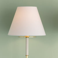 Close-up view of Wedgewood wall sconce with white fabric shade and aged brass accents