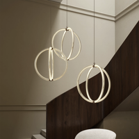 Three modern Luminora pendant lights  hanging above a staircase.
