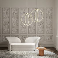 Modern living room with a white sofa, decorative Luminora pendant light, and a round wooden table.