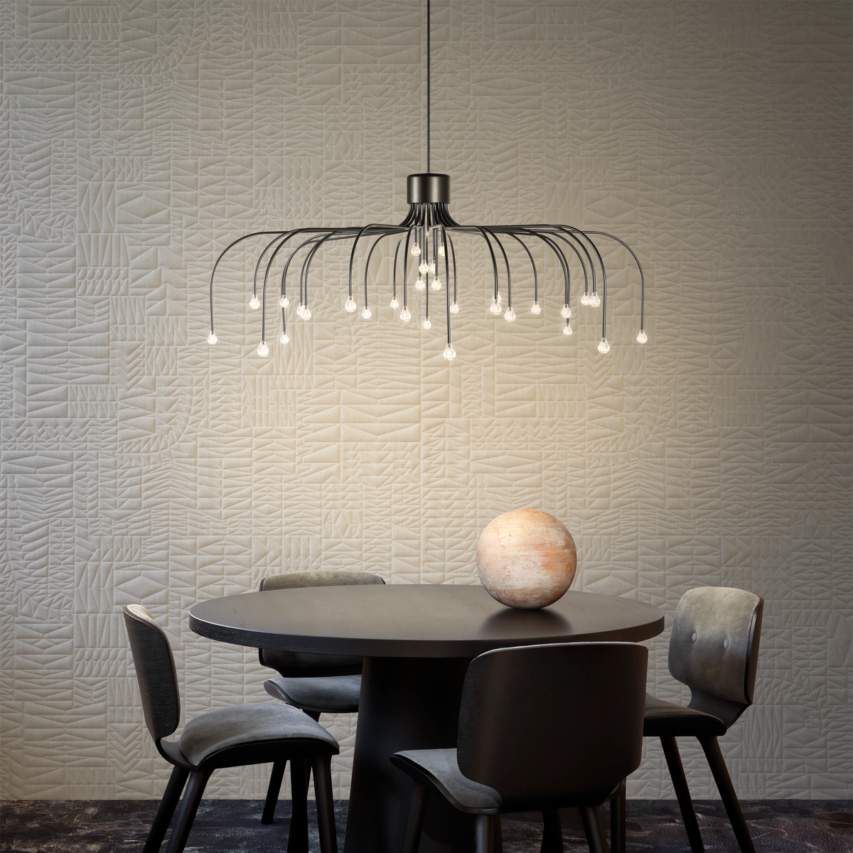 Starfall Pendant Light hanging above a dining table with chairs in a room with textured walls.
