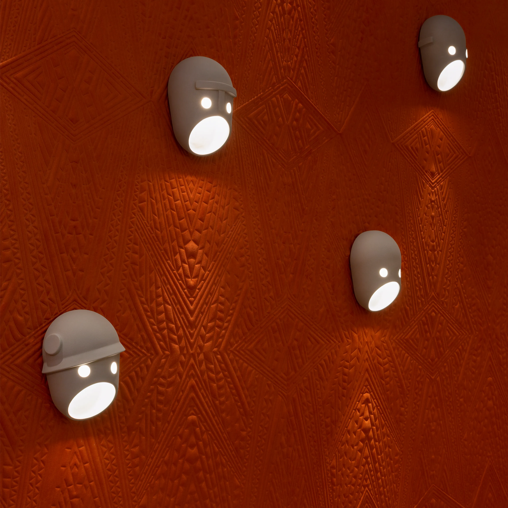 Four Party Wall Lights in grey ceramic on a red patterned wall