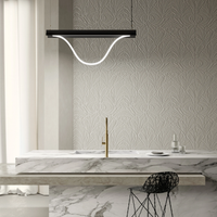 Modern kitchen with marble countertop, gold faucet, and Tubelight pendant light.