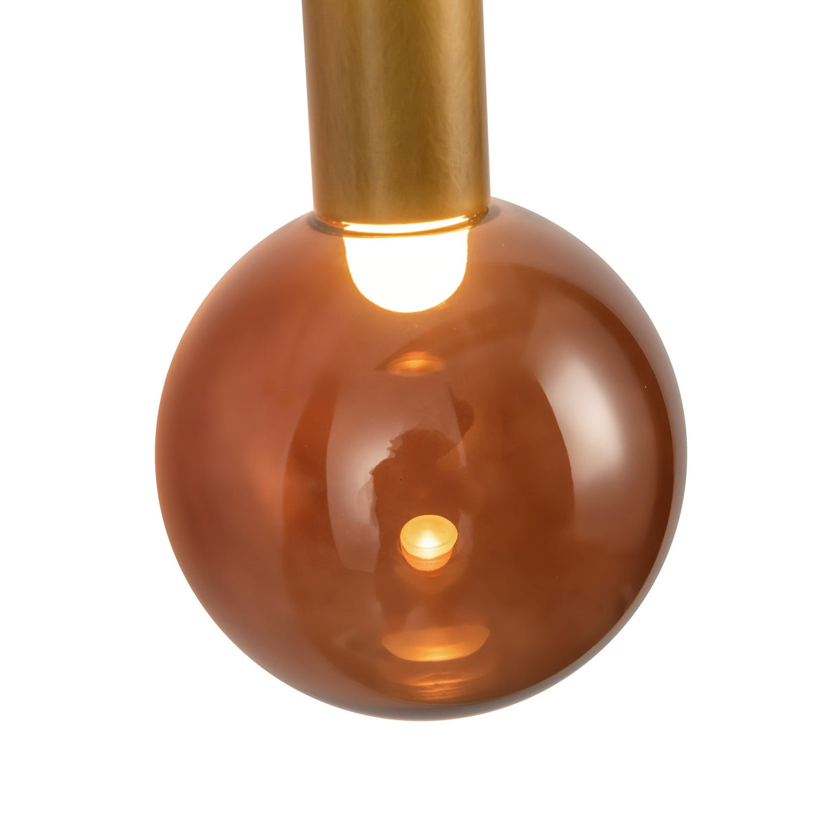 Close-up view of Kuzco Reese wall sconce with vintage brass finish and amber glass globe