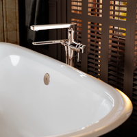 Close up view of MANIFESTO™ THERMOSTATIC SINGLE HOLE FLOOR MOUNT TUB FILLER TRIM mounted to bathtub in bathroom.