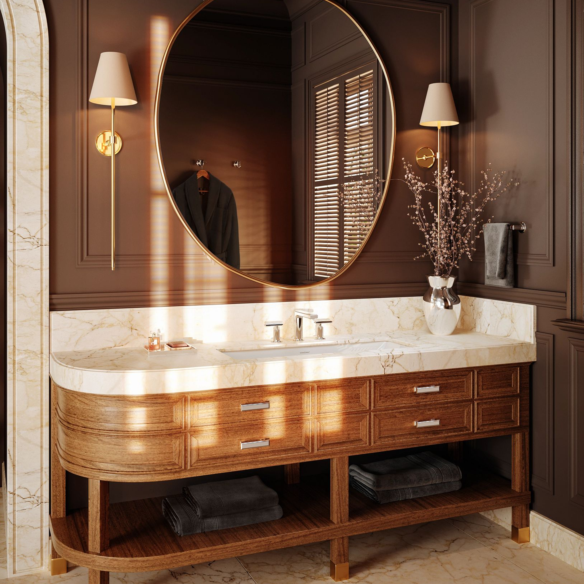 Luxury bathroom vanity featuring a white marble countertop with a Manifesto polished chrome widespread faucet, wood cabinetry, and a large round gold-framed mirror.