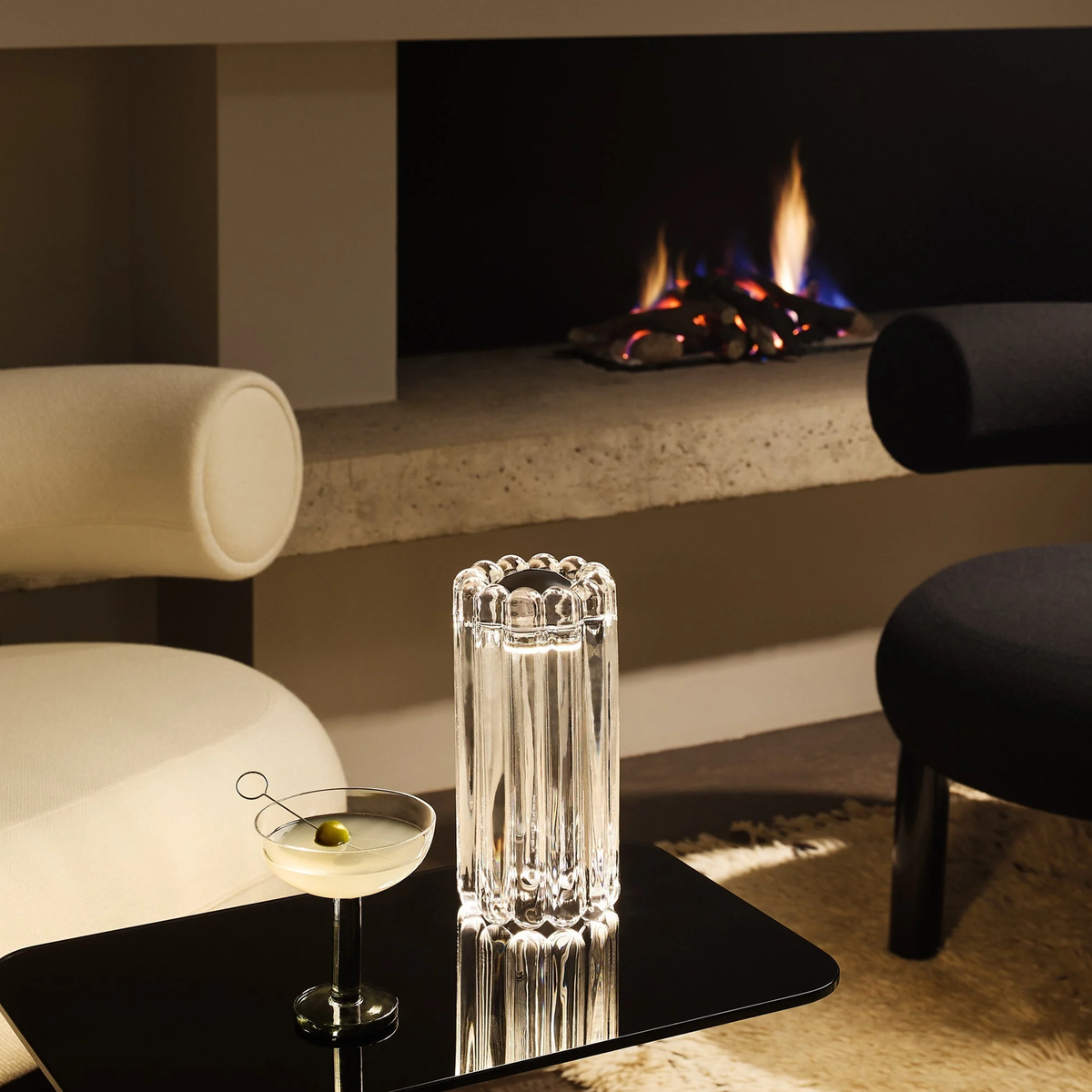 Tom Dixon Press LED Table Lamp  in clear glass on black side table near fireplace