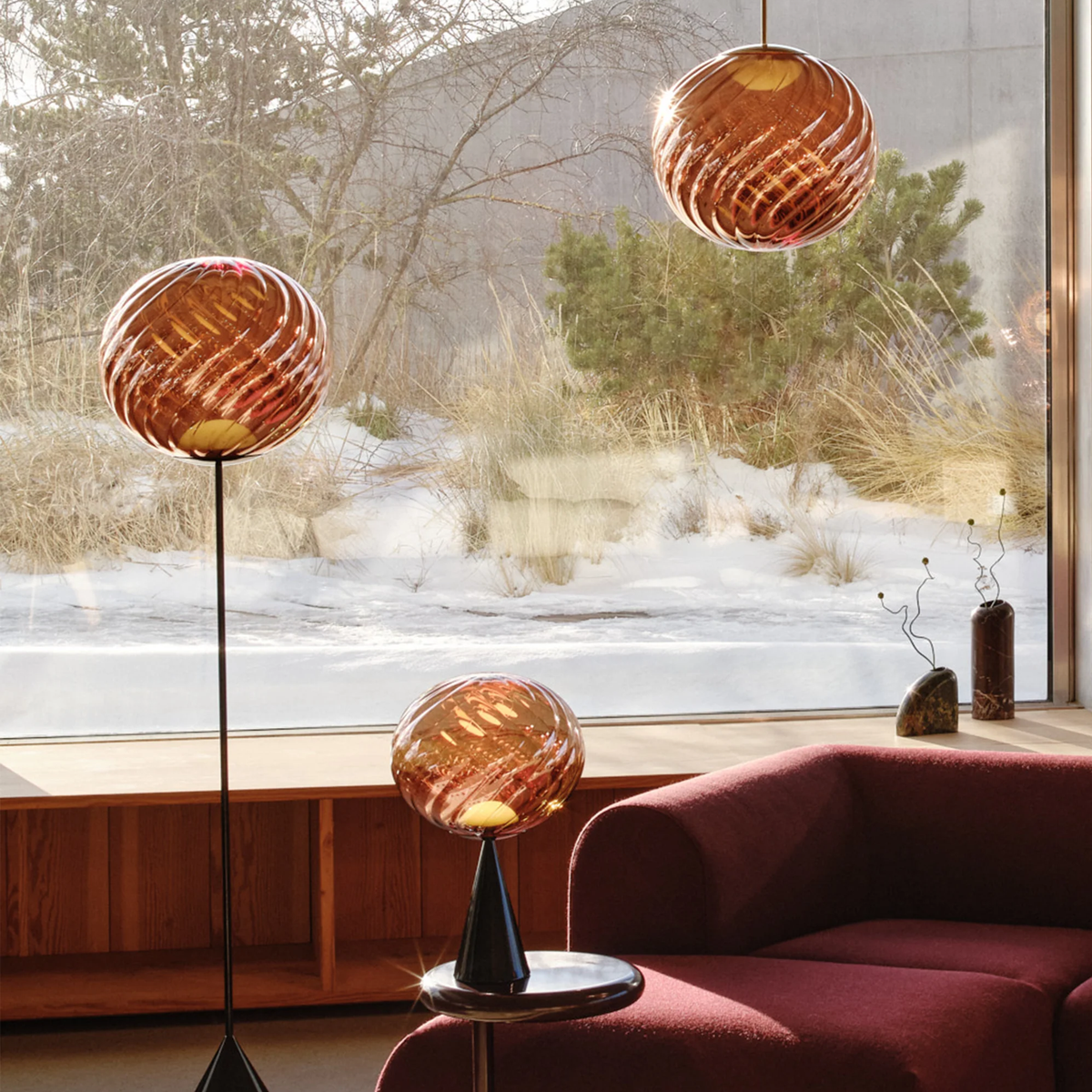 Tom Dixon Whirl Table Lamp on black base in cozy living room with Whirl floor lamp and pendant.
