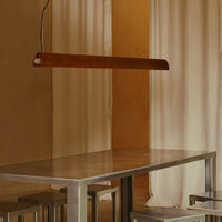 The minimalist Flos Seki-Han suspension fixture highlights natural wood grain and clean architectural lines in a contemporary dining space
