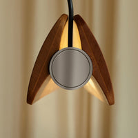 Close-up view of the end detail of Flos Seki-Han suspension light, featuring sculpted solid wood fins arranged around a circular brushed metal center.